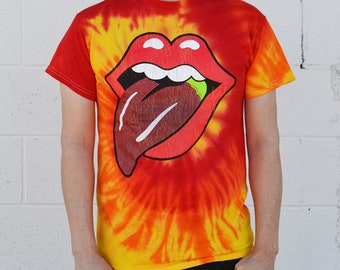 May include: A red, yellow, and orange tie-dye t-shirt with a large graphic of a red mouth with a black tongue sticking out. The tongue has a green design on it.