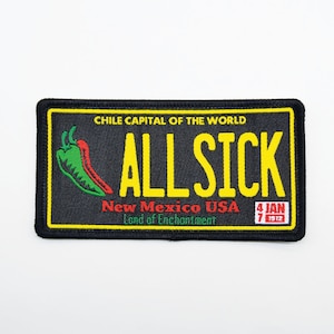 May include: Black and yellow embroidered patch with a green and red chili pepper, the text "CHILE CAPITAL OF THE WORLD ALL SICK", and the text "New Mexico USA Land of Enchantment 4 JAN 1912".