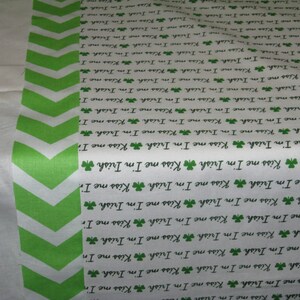 May include: White fabric with a green chevron pattern and the repeated text "Kiss me I'm Irish" with a shamrock symbol.