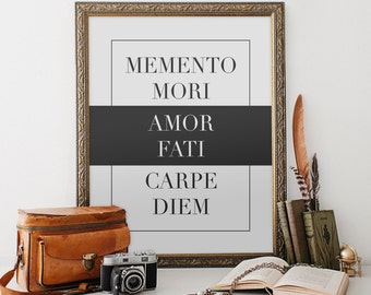 May include: A framed print with the text "Memento Mori, Amor Fati, Carpe Diem" in black lettering on a white background. The frame is gold and ornate.