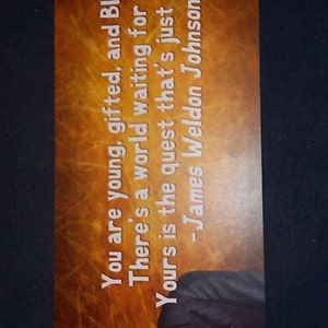 May include: A motivational quote by James Weldon Johnson on a brown background with a black and white photo of a man in a suit. The quote reads: "You are young, gifted, and Black. There's a world waiting for you. Yours is the quest that's just begun."