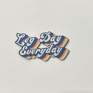 May include: A blue and white retro-style graphic with the text "Leg Day Everyday" in a rainbow colour scheme.