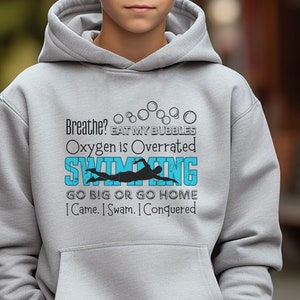 May include: Gray hooded sweatshirt with a blue and black graphic print that says "Breathe? Eat my bubbles. Oxygen is overrated. Swimming. Go big or go home. I came. I swam. I conquered."