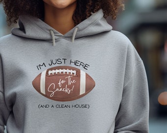 May include: Gray hoodie with a football graphic and the text "I'm just here for the snacks! (and a clean house)"