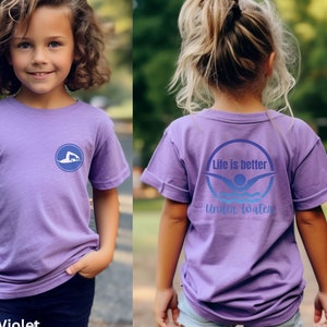 May include: A purple short-sleeved t-shirt with a blue circle graphic on the front and the text "Life is better underwater" with a blue circle graphic on the back.