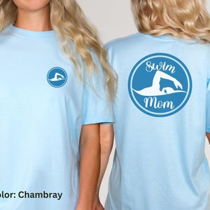May include: Light blue t-shirt with a blue circle on the front and a blue circle with the text "Swim Mom" on the back. The circle on the back features a white silhouette of a swimmer.