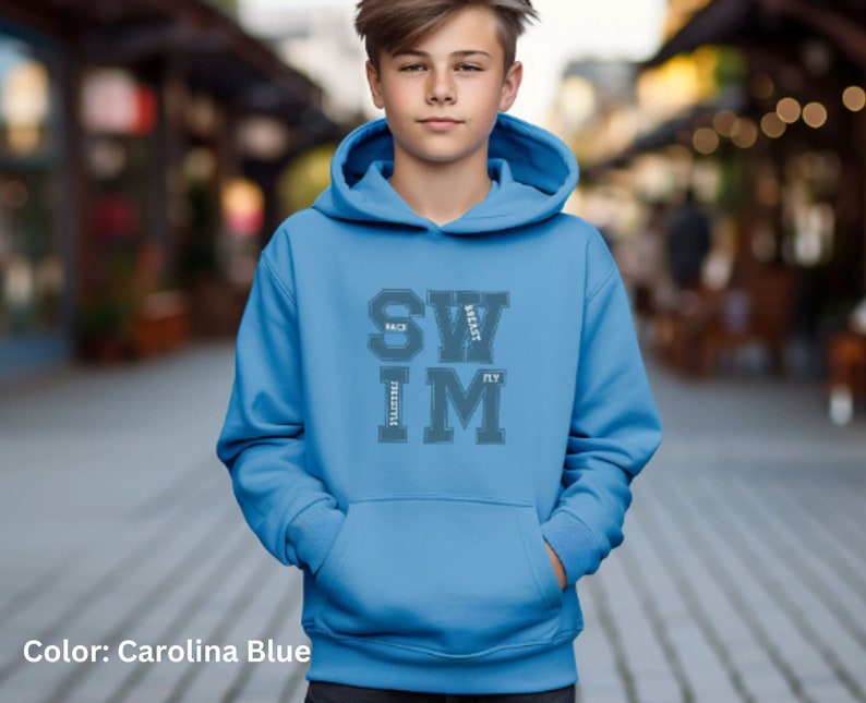 May include: Carolina blue hoodie with a front pocket and drawstring hood. The hoodie features the words "SWIM" and "BACK, BEAST, LIFESTYLE, FLY" in a gray, collegiate-style font. The color is described as Carolina Blue.