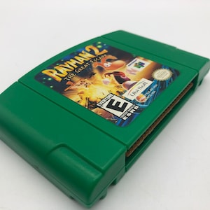 May include: Green Nintendo 64 game cartridge for Rayman 2: The Great Escape. The game is rated E for Everyone by the ESRB. The game is published by Ubi Soft.