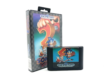 May include: A Sega Genesis video game cartridge for Sonic the Hedgehog 2. The cartridge is black with a blue label featuring Sonic and Tails. The label also includes the Sega Genesis logo and the game title.