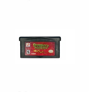 Puede incluir: Un cartucho de juego Game Boy Advance negro con una etiqueta roja. La etiqueta presenta el texto "Frogger's Adventures:  The Lost  of the  Frog" y una rana verde con una serpiente amarilla.
