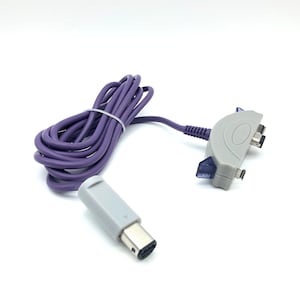Op de afbeelding: Paarse Game Boy Advance-verbindingskabel met een grijze connector aan het ene uiteinde en een grijze connector met twee poorten aan het andere uiteinde.