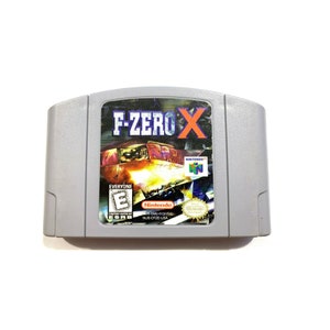 May include: A gray Nintendo 64 game cartridge for the game F-Zero X. The cartridge has a colorful image of a futuristic race car on the front. The game is rated E for Everyone by the ESRB.