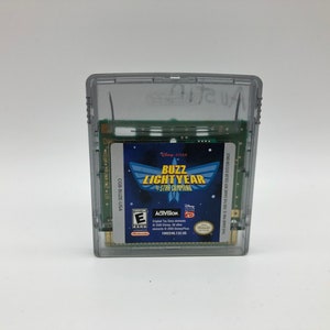 Op de afbeelding: Een grijze Game Boy Color-spelcartridge met een blauw label waarop Buzz Lightyear van Star Command te zien is. Het label heeft de tekst "Disney Pixar Buzz Lightyear Star Command" en een classificatie van "E" voor iedereen.