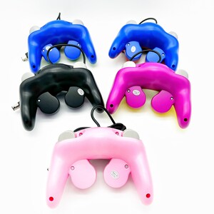 May include: Four GameCube controllers in different colors: black, blue, pink, and purple. Each controller has a cord attached.