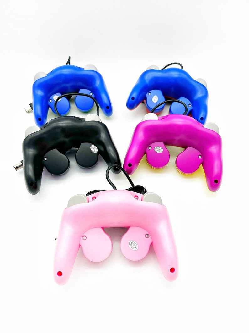 May include: Four GameCube controllers in different colors: black, blue, pink, and purple. Each controller has a cord attached.