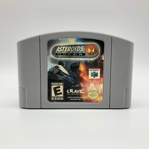 Puede incluir: Un cartucho de juego gris de Nintendo 64 para Asteroids Hyper 64. El juego está clasificado como E para todos por la ESRB. El cartucho está hecho por Crave Entertainment.