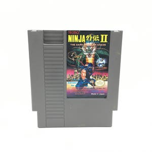 May include: A gray Nintendo Entertainment System (NES) game cartridge for Ninja Gaiden II: The Dark Sword of Chaos. The cartridge features a colorful label with a green dragon and a ninja figure.