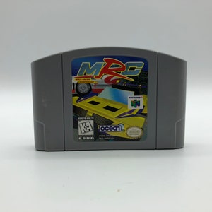 Könnte beinhalten: Eine graue Nintendo 64-Spielkassette für das Spiel "MRC: Mini Racing Championship". Das Spiel zeigt ein gelbes Rennfahrzeug mit violetten Akzenten auf der Vorderseite der Kassette.