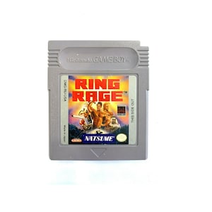 Puede incluir: Un cartucho de Game Boy gris con una etiqueta que dice "Ring Rage" y "Natsume". La etiqueta presenta una ilustración colorida de dos hombres boxeando.