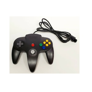 Puede incluir: Un mando negro de Nintendo 64 con una palanca analógica gris, botones rojo, verde, azul y amarillo, y un cable negro.