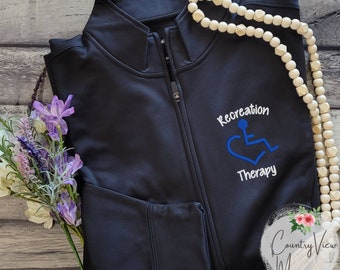 Pode incluir: Casaco preto com zíper com o texto "Recreation Therapy" e um símbolo de cadeira de rodas azul bordado na frente.