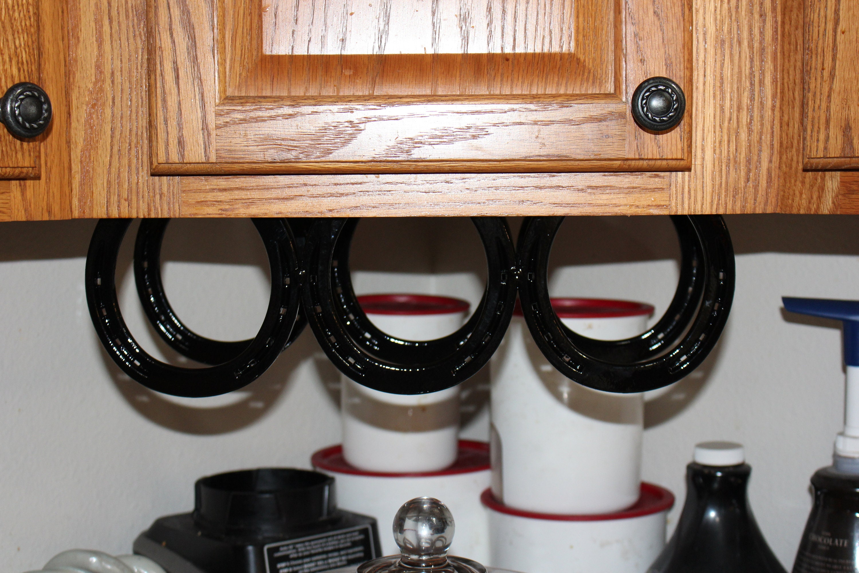 Horseshoe under the counter wine rack holds three bottles