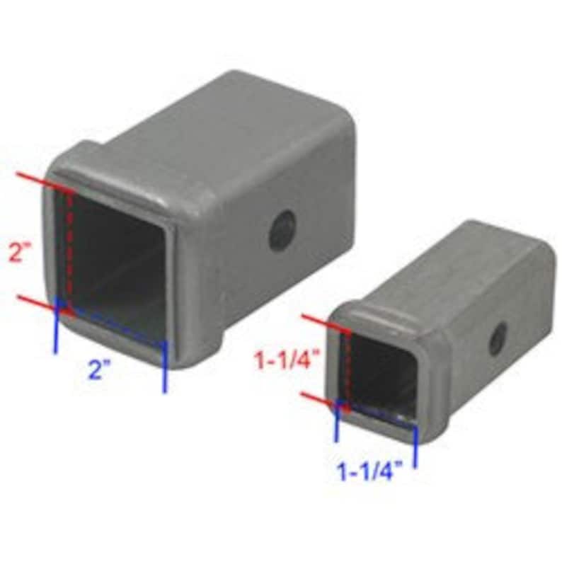 May include: Two silver metal trailer hitch receiver extension adapters. The larger adapter is 2 inches by 2 inches and the smaller adapter is 1-1/4 inches by 1-1/4 inches.