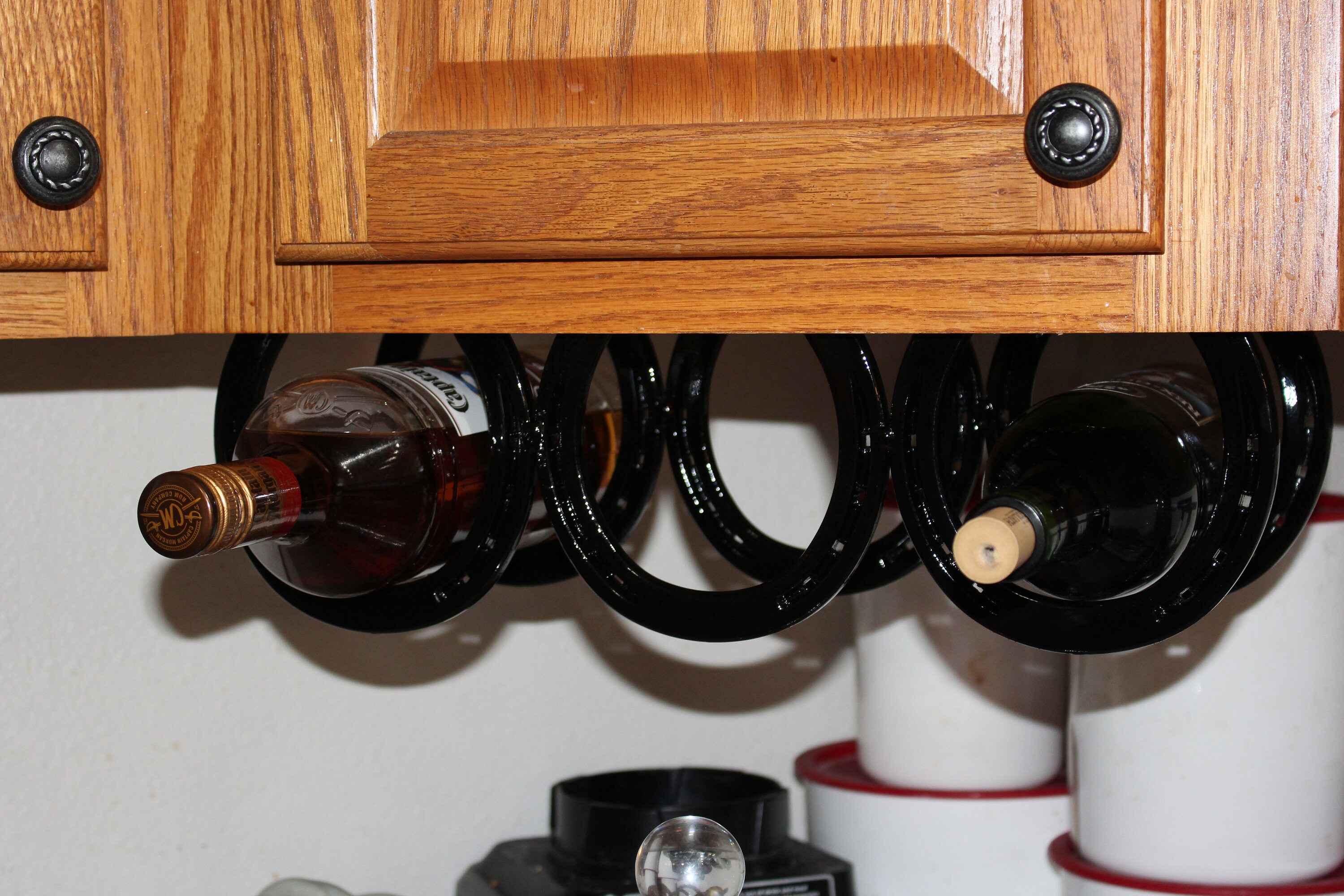 Horseshoe under the counter wine rack holds three bottles