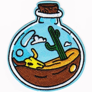 Può includere: Toppa ricamata raffigurante un paesaggio desertico all'interno di una bottiglia di vetro. Il disegno comprende un cactus verde, un teschio giallo, sabbia e un cielo blu con nuvole. La bottiglia ha un tappo di sughero e un contorno bianco.