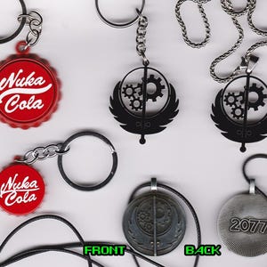 May include: A set of Fallout themed keychains and necklaces. The keychains feature a red and white Nuka Cola bottle cap and a black metal Fallout logo. The necklaces feature a black metal Fallout logo and a silver metal pendant with the year 2077.