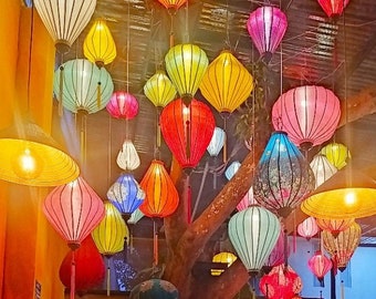 May include: A collection of colorful paper lanterns hanging from the ceiling of a restaurant. The lanterns are in various shapes and sizes, and they are all lit up. The lanterns are a popular decoration in many Asian countries.