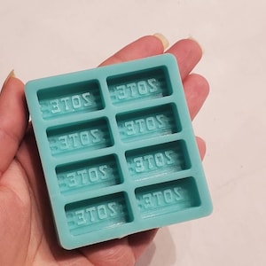 May include: A teal blue silicone mould with six rectangular cavities. Each cavity has the word "3TOS" embossed in the bottom.