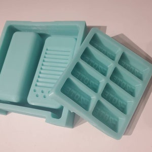 May include: A light blue silicone mold with two parts. One part is a rectangular mold with eight rectangular cavities, each labeled "STORE". The other part is a larger mold with two rectangular cavities.