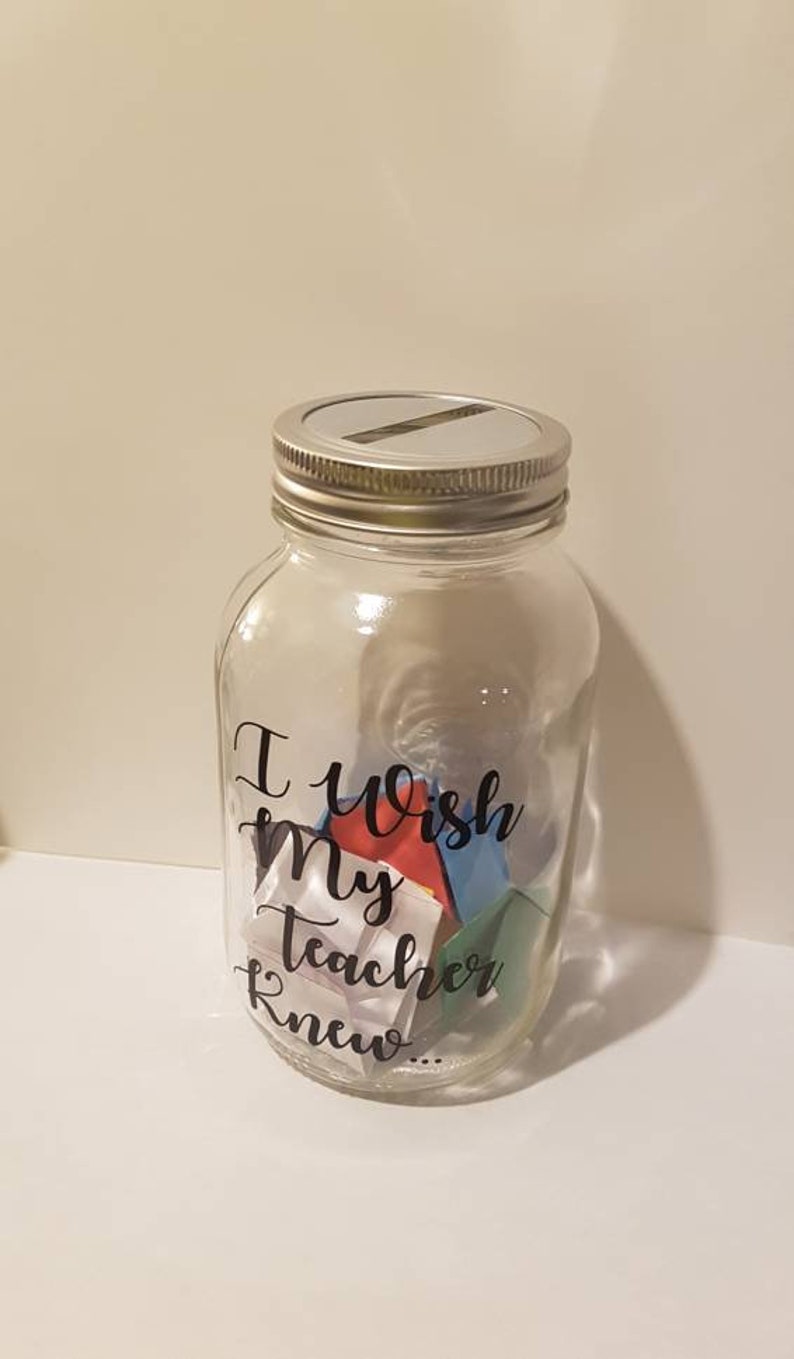 May include: A clear glass jar with a silver lid and a black vinyl sticker that says "I wish my teacher knew..." The jar is filled with colorful folded paper notes.