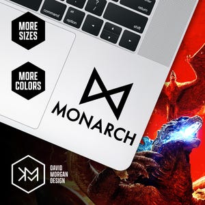 May include: A white laptop with a black sticker that says "MONARCH" with a stylized infinity symbol. The laptop also has stickers that say "MORE SIZES" and "MORE COLORS". The design is by David Morgan.