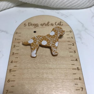 May include: A wooden growth chart with a sunflower pattern dog cutout. The chart has a ruler on the side with markings from 0 to 7 inches. The text "5 Dogs and a Cat" is printed at the top of the chart.