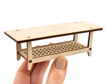 Könnte beinhalten: Ein kleiner Holztisch mit einem Lattenrost und einer glatten Oberseite. Der Tisch ist aus hellem Holz und hat eine natürliche Oberfläche.