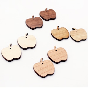May include: Wooden apple-shaped cutouts in various shades of brown and tan. Each cutout has a small hole at the top and a stem detail. The cutouts are arranged on a white surface.