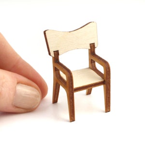 May include: A miniature wooden chair with a light brown finish and a slightly curved back. The chair is made of plywood and has a simple, modern design.