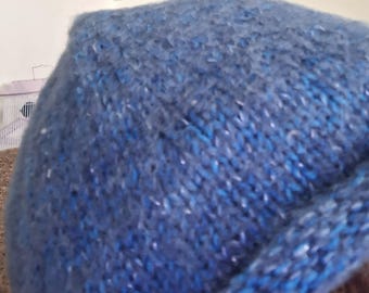 Rolled rim blue hat knitted with merino wool, mylar sparkle, alpaca, and silk yarn.  Extra soft!  A bluebird pin is on the hat.  Available.