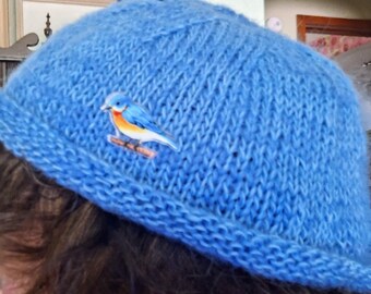 Rolled rim blue hat knitted with merino wool, mohair and silk yarn.  Extra soft!  A bluebird pin is on the hat.  Available. Gift.