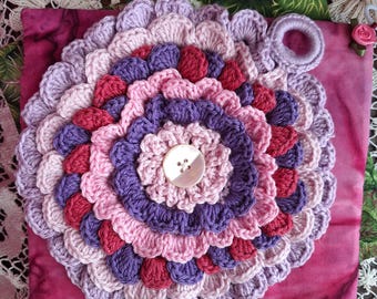 Set of 3 handmade potholders.  1 is a cotton crocheted flower with ruffled petals in purples and dark pink.  There are 2 square fabric PH's.