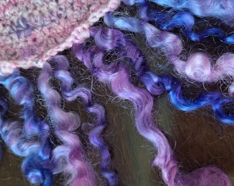 Trivet with purple wool locks surround a cute crocheted pink circle with nips of purple in the yarn.  Gift.  Available now.