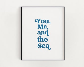 May include: A framed print with the text "You, Me, and the Sea" in a blue font on a white background.