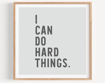 May include: A framed print with a light gray background and the text "I CAN DO HARD THINGS." in black.