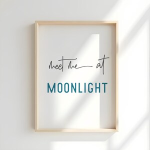 May include: A framed print with the text "Meet me at MOONLIGHT" in a teal blue color. The text is in a modern, handwritten font.