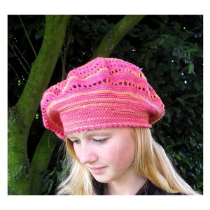 May include: A pink and yellow crocheted beret with a lacy design.