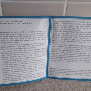 May include: A vintage book cover with a blue background and white text. The book is titled "The Little Mermaid" by Hans Christian Andersen. The cover features a portrait of the author and an illustration of a mermaid.