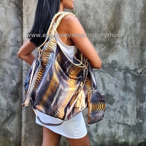 May include: A large, brown, gold, and black snakeskin handbag with a long strap and tassels. The bag is worn by a person with long black hair. The text "www.etsy.com/shop/IndoPython" is visible in the image.