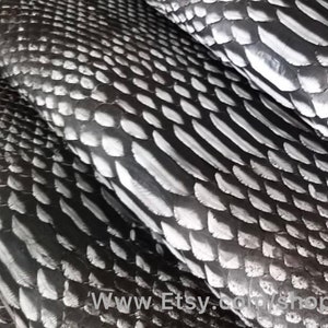 Puede incluir: Primer plano de varias piezas de cuero de serpiente negro y blanco. El cuero tiene un patrón texturizado y escamoso. El texto "www.Etsy.com/shop/indopython" es visible en la esquina inferior derecha de la imagen.